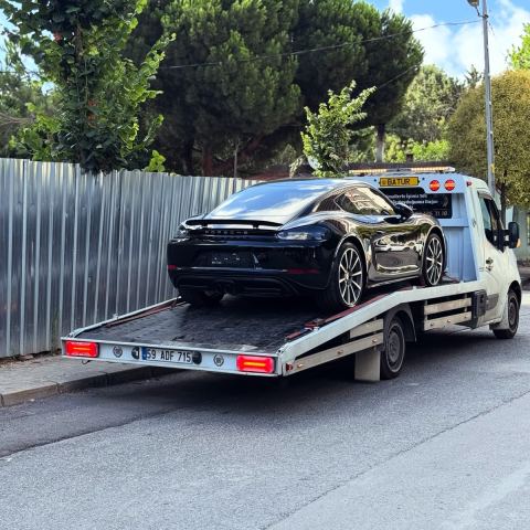 Beyaz spor otomobil oto çekici platformunda hasarsız taşınıyor
