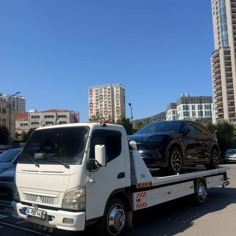Siyah SUV araç Altar Yol Yardım çekicisinde apartman önünden taşınıyor