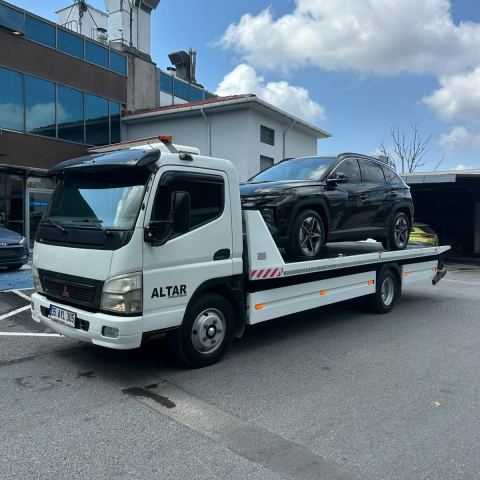 Siyah otomobil oto çekicide ofis binası önünde