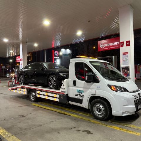 Gri hatchback araç oto çekiciyle akaryakıt istasyonundan taşınıyor