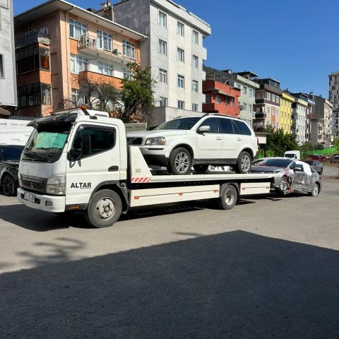 Beyaz otomobil çekici platformunda dar sokakta yükleniyor