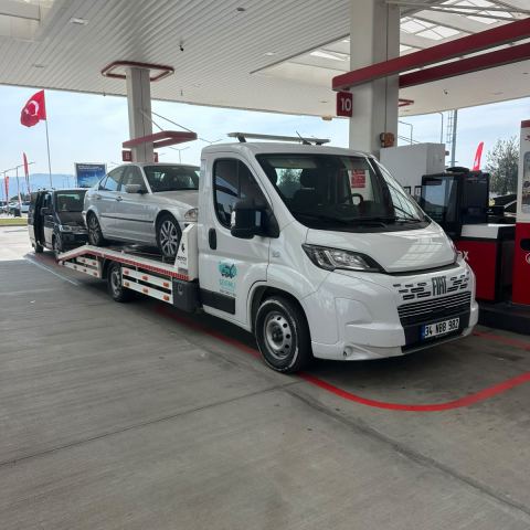 Beyaz otomobil oto çekici platformunda akaryakıt istasyonunda