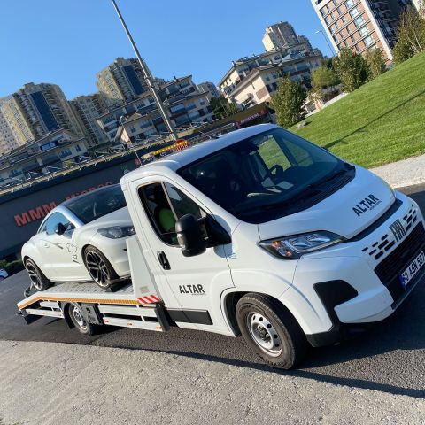 Beyaz minibüs oto çekiciyle Ümraniye şehir merkezinde taşınıyor