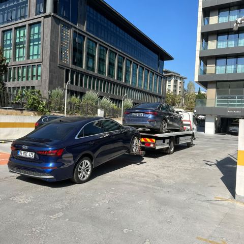 Koyu renk otomobil ofis binası önünde çekici platformunda